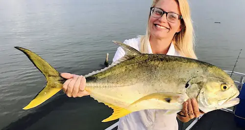 Big Crevalle Jack held by woman angler who caught it on a boat in Florida.